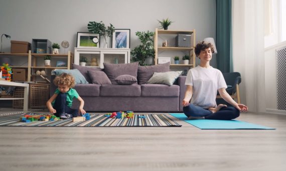 a woman and a child sitting on a rug in a living room